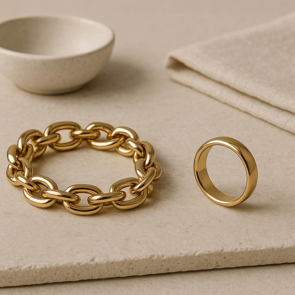 Deux bijoux génériques disposés sur une surface minérale claire dans une composition éditoriale sobre.